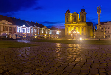 Naklejka premium Night view of Roman Catholic Dome and Trinity Column on Unirii Square, Timisoara, Romania