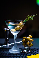 Cold Martini with olives in a bar