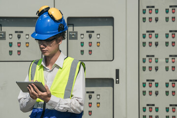 Industrial engineer working on a control panel in an urban setting, adjusting settings to optimize performance and ensure safety protocols.