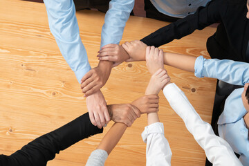 Multicultural business people holding hand together in circle. Unity teamwork in office business...