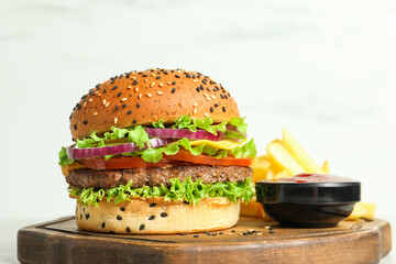 Burger with delicious patty, french fries and sauce on table against light background, closeup