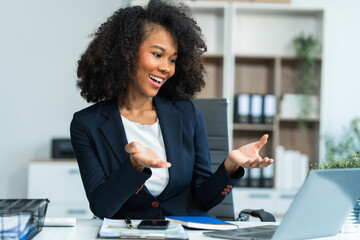 A young African American woman in a blue formal shirt with afro brown hair works as a product...