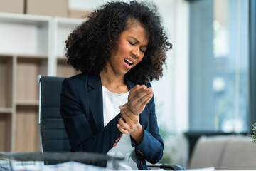 A young African American woman with Afro brown hair in a modern office experiencing office...