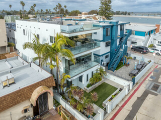 Aerial view of blue and white modern multi story beach homes on Mission Beach with large terrace,...