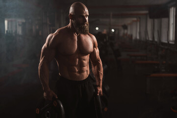 Caucasian bald man posing in the gym.