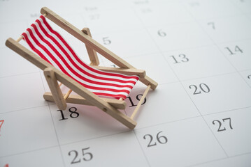 Red beach chair on white blank calendar background copy space. Annual leave travel period for...