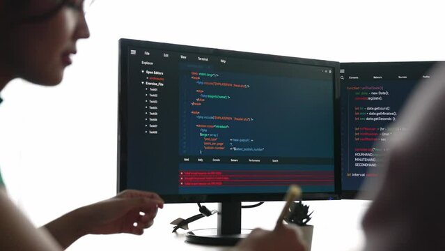 Slow motion back end software developer engineer for computer programming working together on debugging writing computing code, solving complex algorithms display on monitor in office. Burgeoning