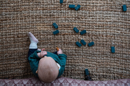 Baby playing on floor with dominoes