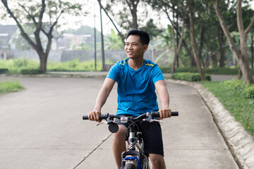 Obraz premium Asian Man Cycling in Blue Sports Shirt for Health and sport Ad.