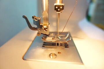 Mechanical sewing needle on a sewing machine. Photo taken from a side angle. Sewing technology