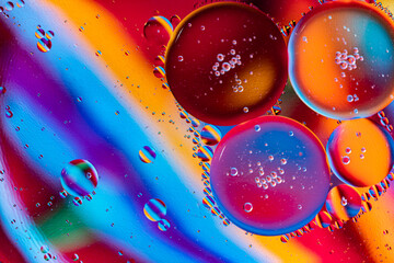 Colorful oil drops floating on the water. Abstract Purple and yellow water bubbles background.