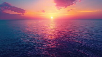 Obraz premium aerial view of the ocean at sunset, with the sky ablaze in shades of orange 