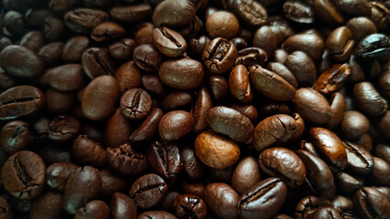 There is a close up of freshly roasted coffee beans on a blue placemat