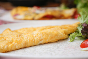 Closeup of Plain Egg Omelette served with herbs on a plate 