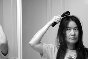 A woman is combing her hair.