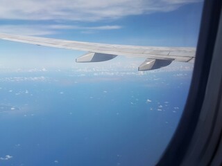 Looking through window aircraft during flight in wing with a nice blue clear sky and beautiful...