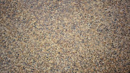 Concrete background or coarse flake stone mixed with small pebbles with a dark brown gradient. For...