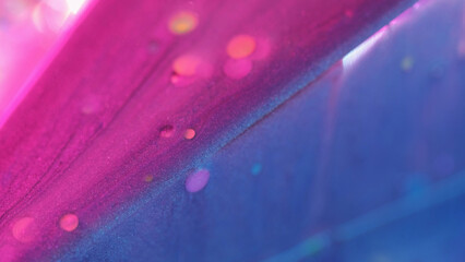 Bokeh glitter. Sparkling texture. Abstract orange circles reflects mixed pink blue shiny fluid...