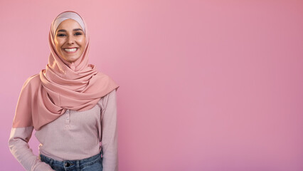 Muslim woman happy face. Portrait of delighted enthusiastic smiling girl in hijab isolated on pink...