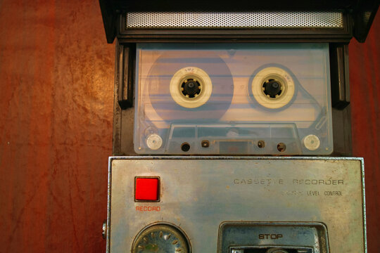 a cassette tape in a vintage tape recorder on wooden table old way listen to music