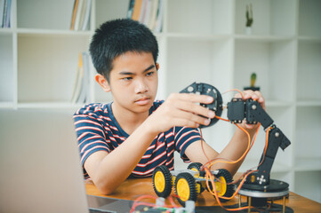 Asian boy learning and studying the work of technology robots.homeschool and science for tech project. playing childhood kids hobby leisure lifestyle people toys robotics technology.