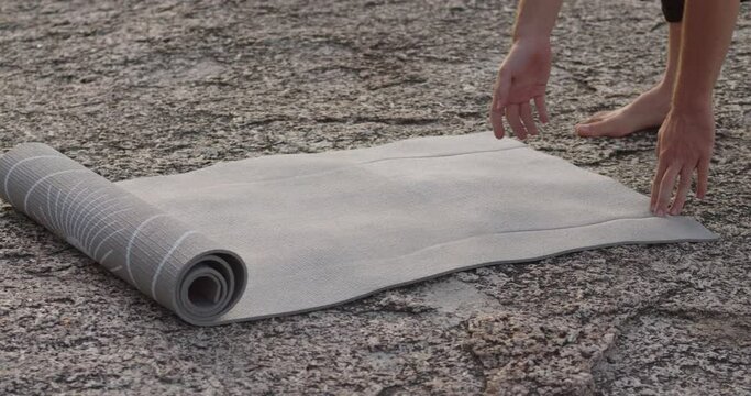 Hands unroll yoga mat for meditation close-up Yoga mat foundation for nature meditations. Yoga mat aligning mental health with outdoor serenity Emblem of harmony between body mind and nature.