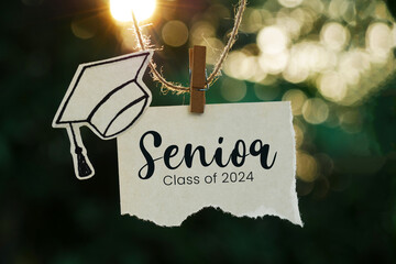 Senior class of 2024 on a note paper hanging on rope with bokeh background