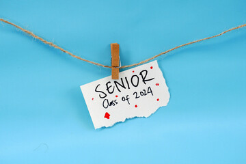 Paper stapled to string with the words Senior class of 2024