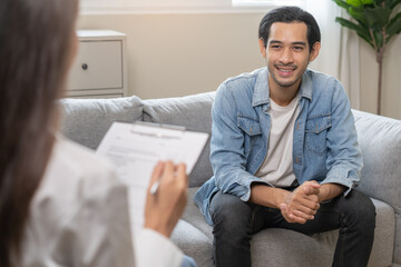 Psychology, depression. Happy smile asian young man patient mental therapy explain symptom with...
