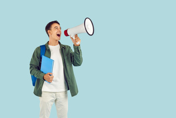 Young male student with megaphone, businessman proclaiming, addressing public, audience, calling, speaking loud in communication, protest or advertisement, attention for commercial promotion
