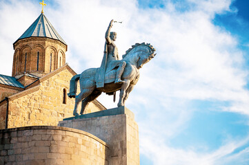 majestic statue of a rider on horseback, poised dramatically in front of ancient stone church,...