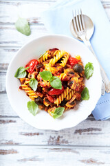 Pasta with cherry tomatoes, and olives. Bright wooden background. Close up.	