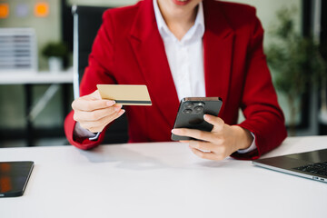 Woman Hand using tablet ,laptop, and holding mobile phone with credit card online banking payment application virtual icon