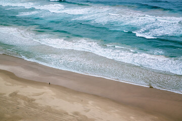 Broadbeach beach surf ocean waves, Queensland Australia, powerful rough sea, lone person figure on sand, nature size scope immense, travel destination tourist tourism holiday vacation