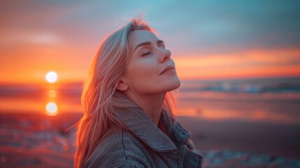 A woman with blonde hair is standing on a beach, looking out at the ocean