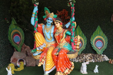 Colorful big figurine of lord Radha and Krishna swinging and playing