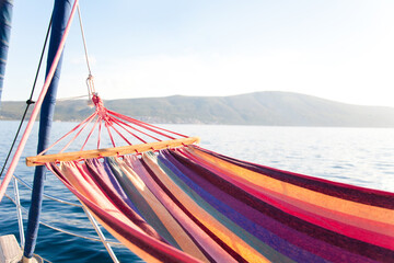 Beach hammock by lake. Relaxation on yacht at sea in summer vacation. Rest on holidays. Concept of...