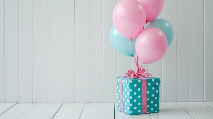 Hot pink paper balloons tied to a turquoise polka-dotted gift box, adding a pop of color against...
