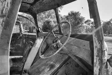 An old truck rusts away in the Australian Outback, engulfed by the bush, a silent relic of time's...