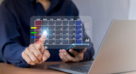 Businessman uses index finger to set agenda on calendar as appointment planning concept.