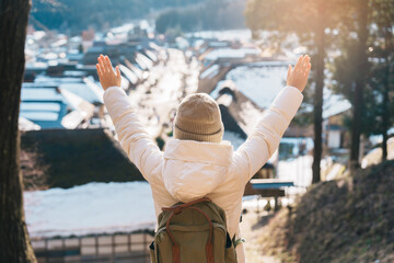 Woman tourist sightseeing Ouchi Juku ancient farmer house village with snow in winter, Traveler...