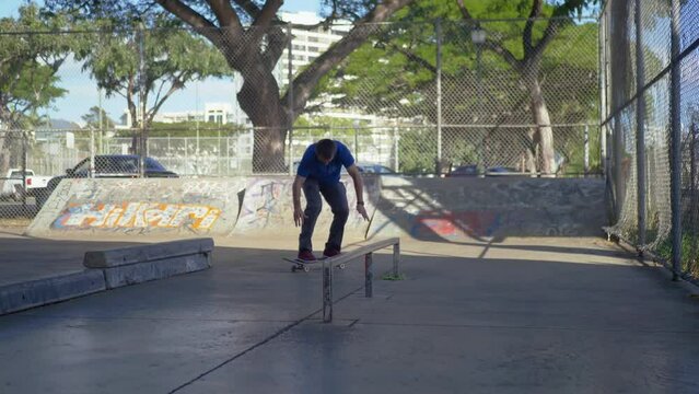 man skateboards under a bridge and then does a kickflip on to the rail