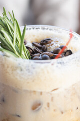 Close-up of an alcoholic drink, carajillo type with coffee beans and rosemary