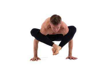 A handsome young man with an athletic body is doing fitness and yoga. White background.