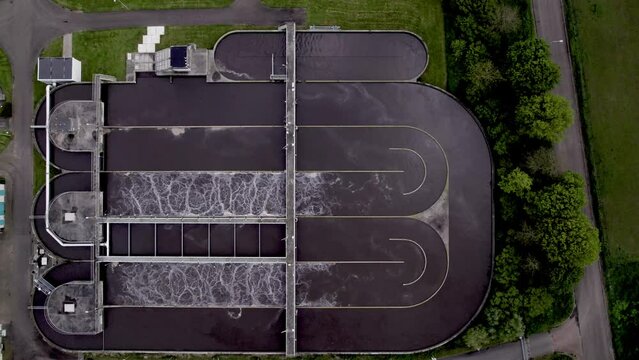 Top down aerial water treatment facility in The Netherlands. Clean tap water infrastructure filtering basin circular waste management.