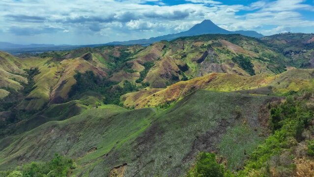 Green Landscape of Philippines with road and green plants during sunny day and beautiful sky. Large Matutum Mountain Volcano in background. Panorama view.