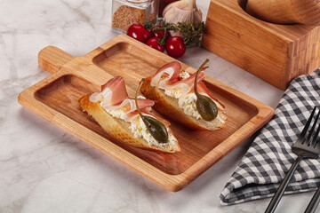 Bruschetta with jamon and caper berries