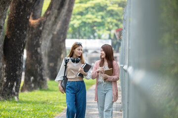Two female student friends were chatting while walking to a classroom on campus.