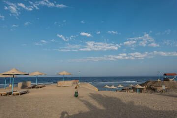 view from the beach to the sea with lot of sunbeds and umbrellas