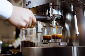 a person pouring coffee into a glass